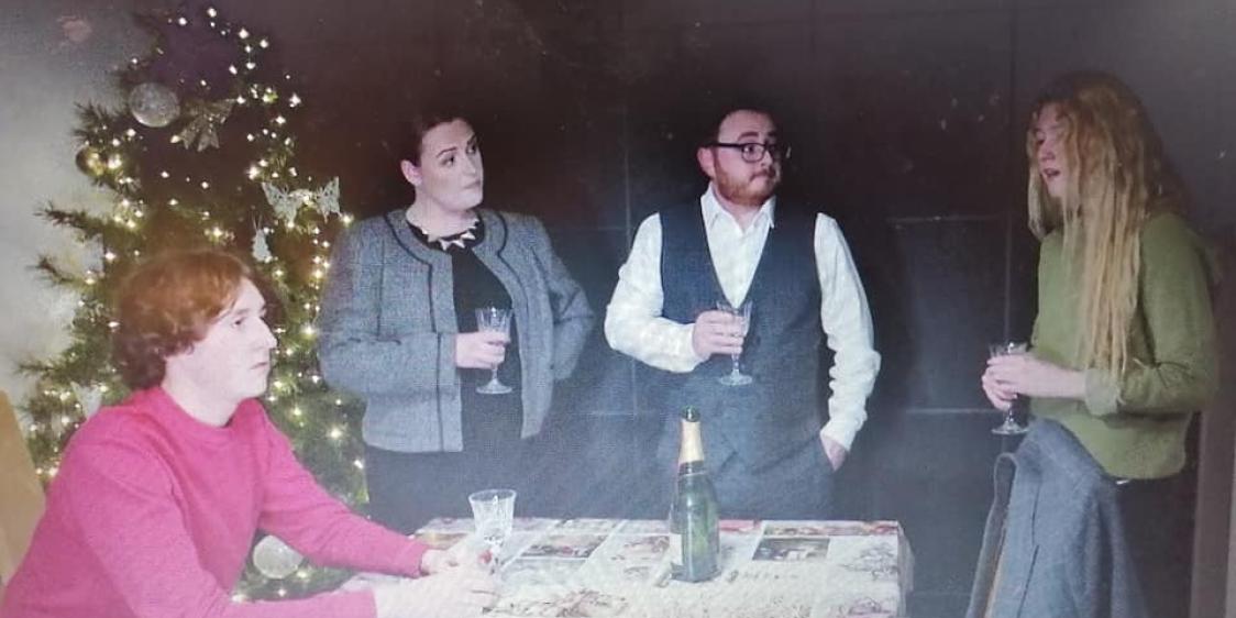 Image of four cast members around a table from the film A Christmas Dream